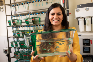 Anu Muppirala with zebrafish tank in lab