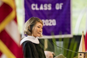 Samie Kim Falvey speaks on stage in front of Class of 2020 banner. 