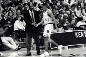 Bill Brown interacts with Kenyon basketball player on court sideline