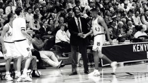 Bill Brown interacts with Kenyon basketball player on court sideline